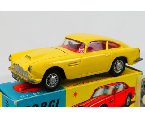 Corgi Toys - A boxed Corgi Toys # 218 Aston Martin DB4. The model in primrose yellow with boidy vent, red interior flat spun 