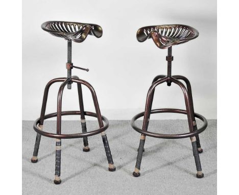 A pair of metal vintage tractor seat bar stools, with revolving seats (2)