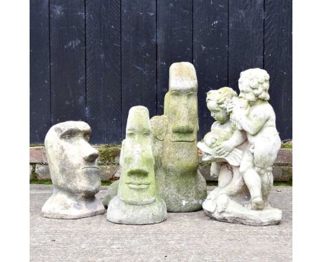 A collection of Easter Island garden ornaments and a cast stone figure group of cherubs, 55cm high (4)