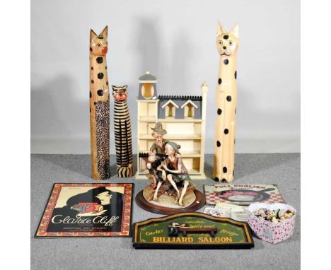 A collection of advertising signs, model cats, Daphne figures and decorative items