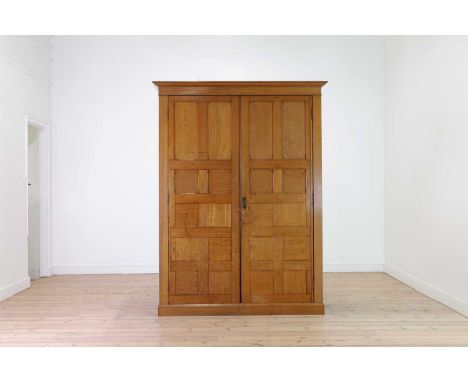 A blonde oak compactum wardrobe,c.1900, the panelled doors enclosing an arrangement of drawers and shelves, 150cm wide64cm de