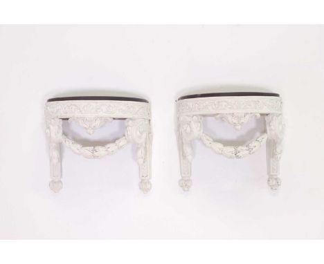 A pair of carved and painted wooden brackets in the manner of Robert Adam,probably 20th century, each with a polished slate t
