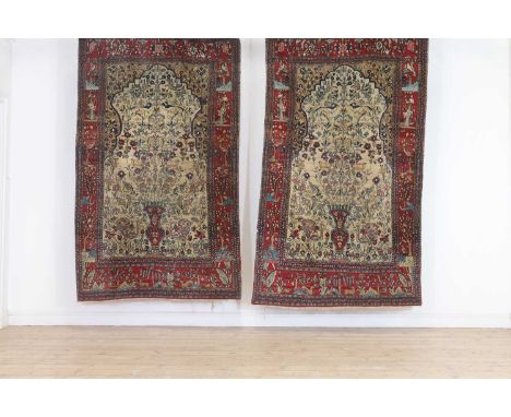 A pair of Persian wool rugs,c.1920s, Isfahan, each with a flowering vase to a pale ground, within a border of stylised foliat
