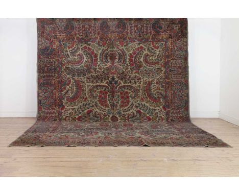 A Kirman wool carpet, early 20th century, Central Persian, woven with an all-over floral design to a pale ground, 367 x 270cm