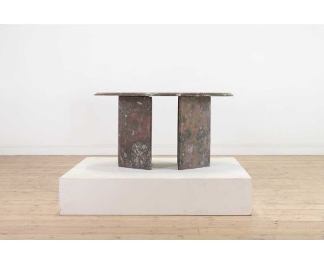 A fossil marble low table, 20th century, the moulded oval top raised on a pair of 'L' shaped supports,89cm wide63cm deep48cm 