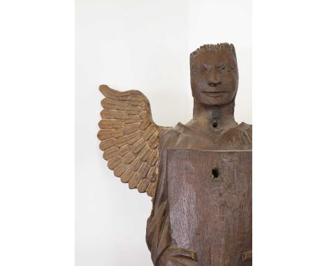 An early oak architectural fragment,17th/18th century, in the form of an angel holding a shield,57cm wide16cm deep65cm highTh