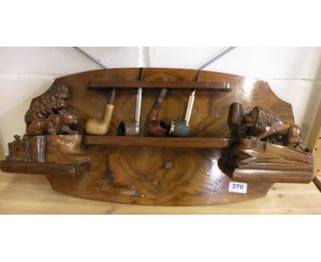A 1930s carved walnut pipe rack and pipes W 60cm