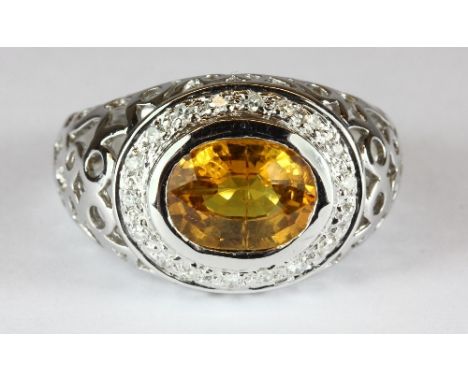 An 18ct white gold ring set with a yellow sapphire surrounded by diamonds (R)