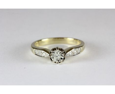 A 9ct gold diamond solitaire ring with diamond set shoulders (K)