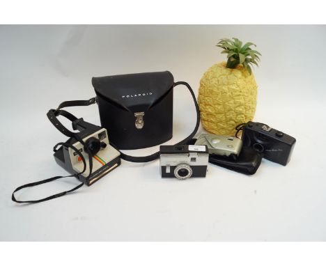 A Polaroid camera, other cameras and an ice bucket