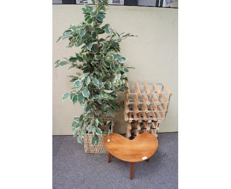 A kidney shaped occasional table, two wine racks and a faux house plant