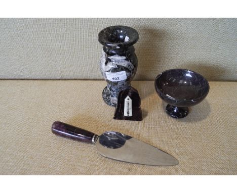 A hardstone urn, thermometer, a bowl and a cake slice