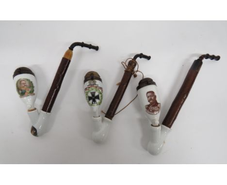 Three Imperial German Pipesconsisting wooden and horn stem.  Lower china mount and china bowls with tin, hinged caps.  All wi