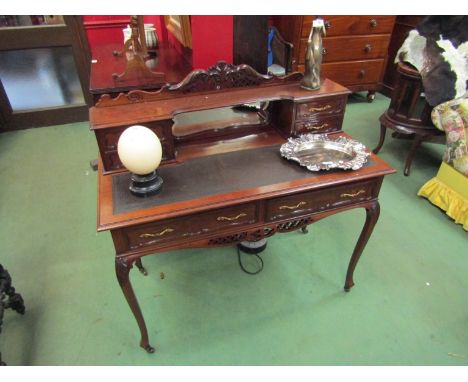A late Victorian mahogany writing desk, the raised four drawer mirror back with carved pediment over two frieze drawers on ac