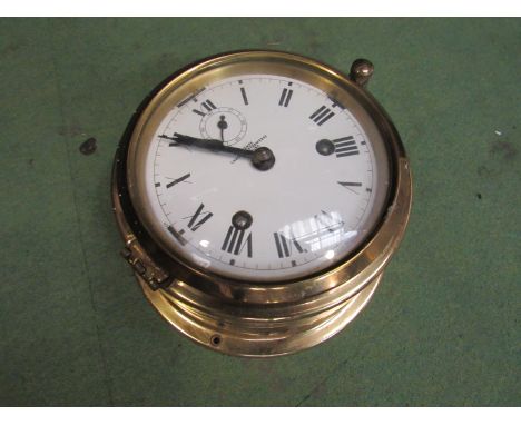 A brass cased German ship's clock with enamel face 