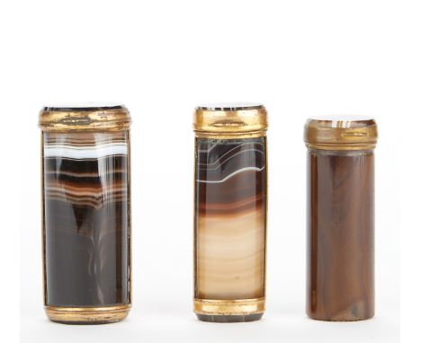 Group of three cylindrical match boxes with agate showing veining in brown, white, and black. The boxes are mounted in gilt m