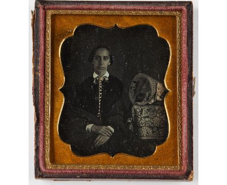 One century daguerreotype portrait photograph of a seated woman next to an ornately decorated tablecloth and bonnet, ca. 1850