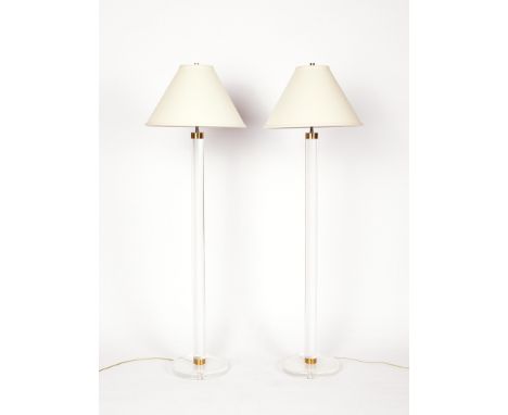 Pair of lucite floor lamps in the manner of Karl Springer. Each features a lucite column on a round lucite base with brass fi
