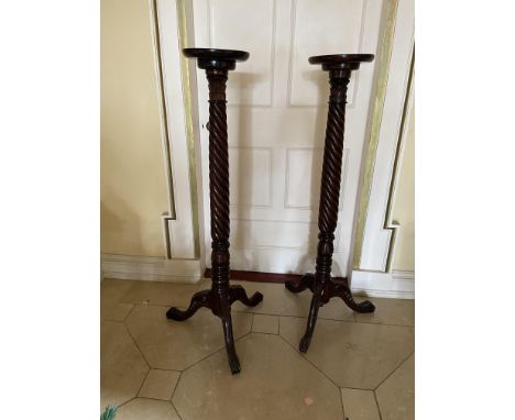 A pair of Chippendale style carved mahogany Torcheres, each with circular top on spiral reeded column and tripod base, 53'' (