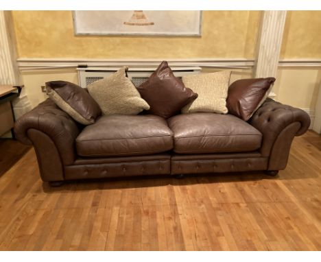 A large four seater hide Club Settee, with double cushion settee and cushion back, raised on bun feet, 98'' (249cms). (1) 