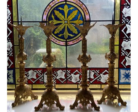 A fine set of 4 Gothic Revival brass Pricket Candlesticks, each with a leaf cast flared top above a three stage stem with cen