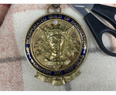 18K GOLD MASTERS BADGE FOR THE INCORPORATED GUILD OF HAIRDRESSERS, WIGMAKERS AND PERFUMERS, blue enamel worded bezel with gol