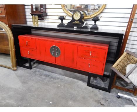 A Chinese lacquer sideboard with red mid section, two flanking short drawers and singular cupboard to reveal one shelf, 190cm