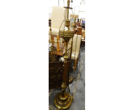 A Victorian brass standard lamp with stepped circular base, acanthus leaves design, on three feet, fluted column, the top a c