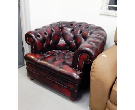 A burgundy leather Chesterfield three seat sofa with button back decoration and matching armchair (2) 