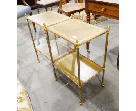 A pair of gilt metal two shelf side tables, with inset leather tops, on turned legs with castors, width 41cm