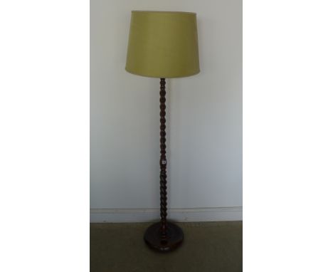 An early 20th century oak floor lamp with barleytwist support on circular support