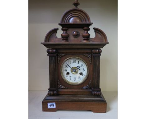 An eight day German mantle clock, walnut case, strikes on gong