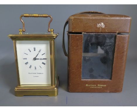 A twentieth century brass carriage clock by Matthew Norman, London  with leather carry case - Height  15cm  handle up
Conditi