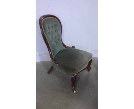 A Victorian walnut button back spoon shaped nursing chair