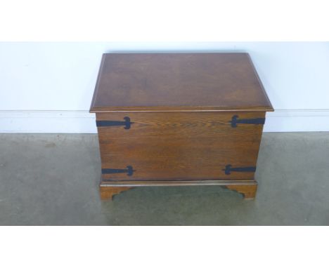A rectangular oak trunk with lift up lid and metal strap fittings - 53cm x 73cm x 52cm 