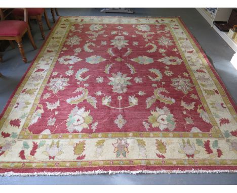 A hand knotted, red ground, Indian Chobi wool carpet with multi coloured floral and foliate designs with double bordered and 
