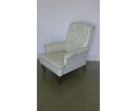 A late Victorian mahogany framed Gentleman's easy chair with button back fabric upholstery, carved supports on turned legs an