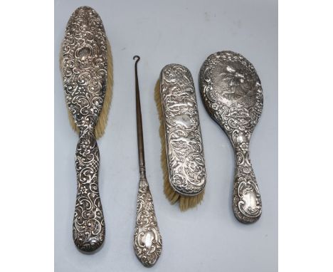 Three silver mounted vanity items to include Edwardian silver brush decorated with a foliate and scrolling repousse, Chester 