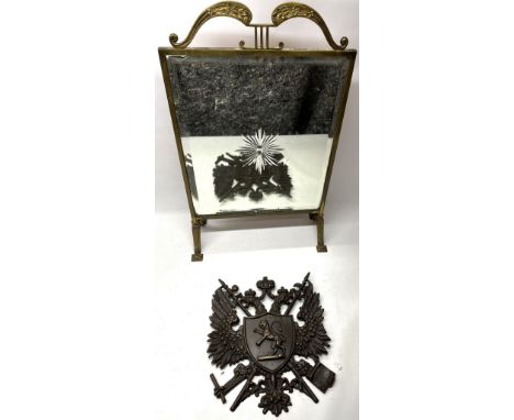 Art Deco brass framed mirror firescreen with leaf scroll handle on angular supports and a cast metal Heraldic wall plaque, W4