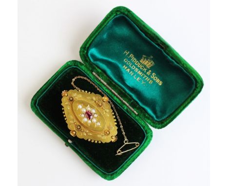 A Victorian ruby and pearl set memorial brooch, comprising a central oval mixed cut ruby measuring 5mm x 3mm, with a cluster 