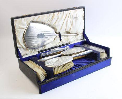 A boxed silver mounted dressing table set by Charles S Green & Co Ltd, Birmingham 1926, comprising a handheld mirror, two hai