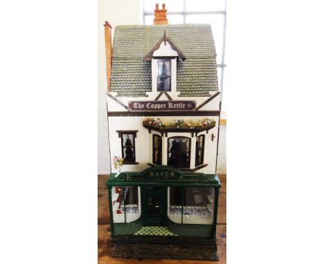 A late 20th century hand made custom built dolls house, circa 1980's, the house modelled as a Victorian baker's shop front wi