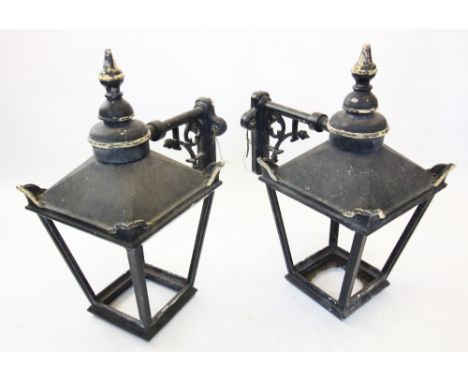 A pair of early 20th century painted metal wall mounted outdoor lanterns, of pagoda form with a spire shaped finial above the