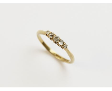 A diamond five stone ring, comprising five graduated old cut diamonds, all claw set in yellow metal to tapering shoulders and
