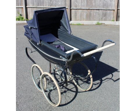 A vintage Silver Cross pram, mid 20th century, the boat shaped body with a folding canopy, raised upon leaf springs with leat