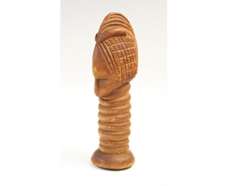 A Tribal figural carving, possibly Dan, Ivory coast, carved as a mask upon a ribbed column in the manner of a ceremonial ladl