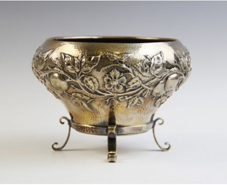 An Arts & Crafts silver bowl by Elkington & Co, London 1901, of tapering baluster form on three scrolling feet, embossed with