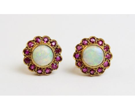 A pair of opal and untested ruby earrings, 20th century, each designed as a circular cabochon opal, within a surround of twel