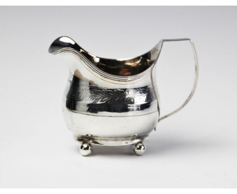 A George III silver cream jug by John Merry, London 1812, of oval baluster form with engraved foliate decoration and cartouch