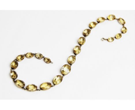 A citrine set riviere necklace, comprising twenty-two oval faceted citrines measuring between 10mm x 7mm and 18mm x 13mm, eac